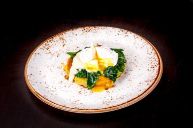 Ispanaklı patates üzerinden pirzola üzerinde haşlanmış yumurta.