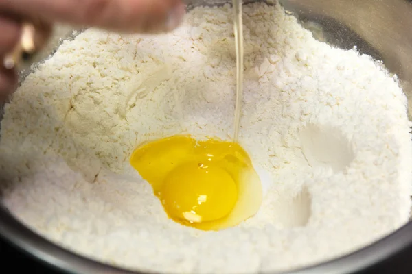 Подготовка теста. Добавьте яйцо в просеянную муку . — стоковое фото
