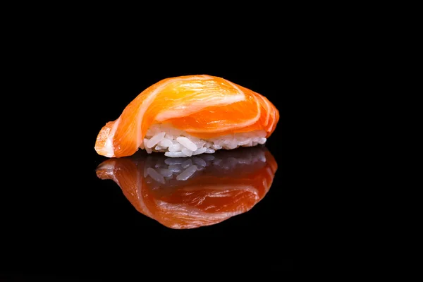 Суши с лососем на черном зеркале — стоковое фото
