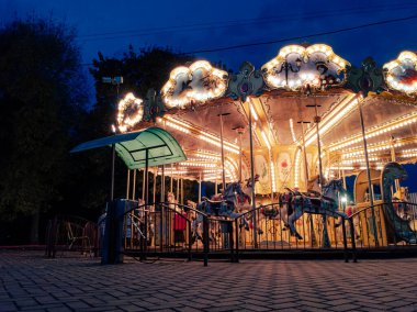 Mavi gecenin karanlığında usulca dönen ışık atlıkarıncaları