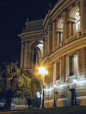 Karanlık bir gece gökyüzünün altında çarpıcı bir şekilde parlayan Avrupa tarihi tiyatro binası cephesi