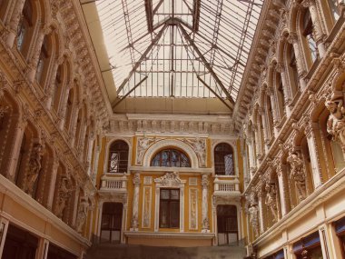 Heykelleri ve büyük kemeri olan tarihi bir alışveriş salonu.