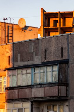 Sıcak akşam ışığında parlayan harap olmuş Sovyet konut binası