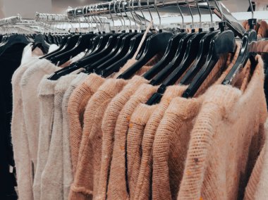 Pastel örülmüş kazaklar, mağaza demiryollarında sergilenen boyut etiketleri.