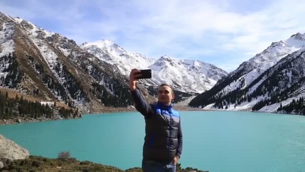 Joven exitoso blanco caucásico hombre haciendo selfie en el fondo de hermosa montaña fantástico invierno paisaje — Vídeos de Stock