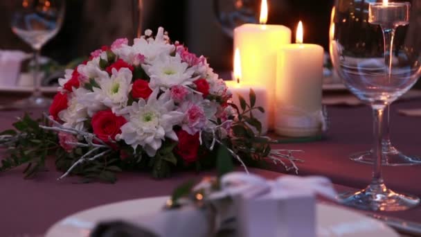 Krásný drahý stůl sloužící pro romantickou večeři se svíčkami a červenými růžemi — Stock video