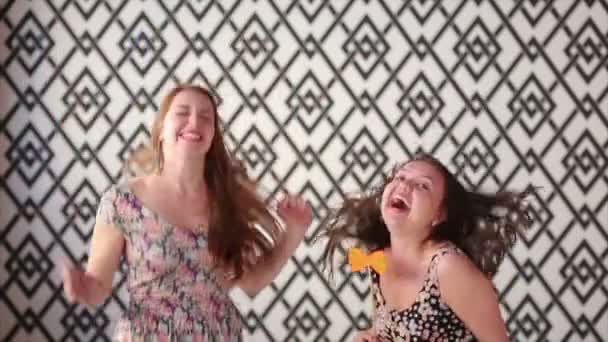 Letní portrét dvou hezká brunetka girl přátel se baví s Foto doplňky a příslušenství. Zpěv, skákání, tanec a usmíval se. Ležérní styl, světlý makeup, růžové rty. Bílé pozadí. — Stock video