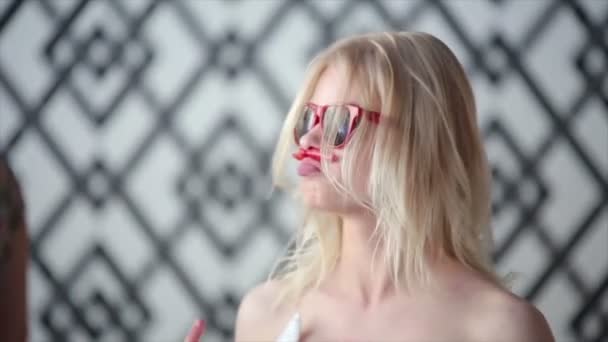 Lifestyle Zeitlupe Porträt der schönen tanzenden sexy Mädchen Hipster trägt roten Lippenstift und kurzen Sommerkleid stilvolle helle Outfits und Sonnenbrille und Spaß haben. posiert für die Kamera in — Stockvideo