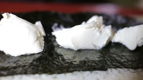 Set de sushis Philadelphie préparé avec du fromage à pâte molle par le maître des sushis dans un studio — Video