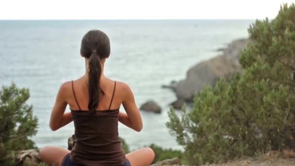 Fitness brunett tjej gör yoga vid havet med avkopplande utsikt över bergen — Stockvideo
