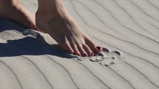 Belles jambes féminines jouant avec le sable sur la plage de sable de la mer — Video