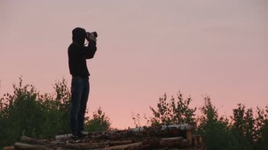 Fotoğrafçı silüeti dslr fotoğraf makinesi günbatımı ve gündoğumu arka plan, fotoğraf ve yapımı fotoğraf çeker