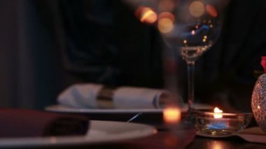 Mumlar ve kırmızı güllerle romantik bir akşam yemeği için pahalı bir masa.