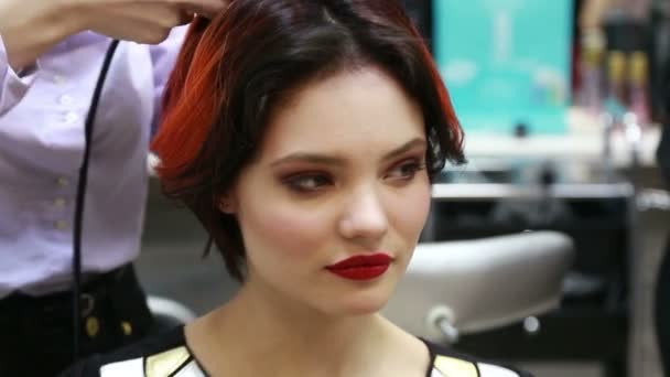 Giovane modello di moda sexy con rossetto rosso trucco luminoso ballare ridere e scherzare mentre viene fatto un taglio di capelli — Video Stock