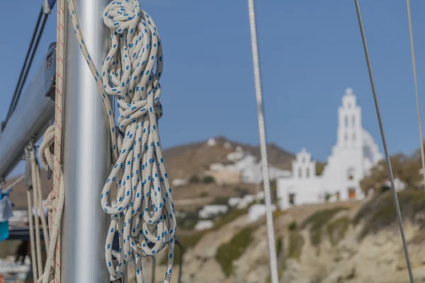 Σχοινιά για το κατάρτι ενός ιστιοπλοϊών σε φόντο ελληνικό νησί — Φωτογραφία Αρχείου