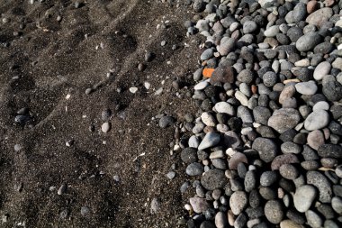 Taşlar üzerinde siyah kum plaj