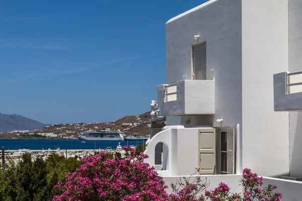 Παραδοσιακή Ελλάδα λευκό σπίτι με πικροδάφνη αυξήθηκε κόλπο λουλούδια σε φόντο θάλασσα με πλοία και ferry boat — Φωτογραφία Αρχείου