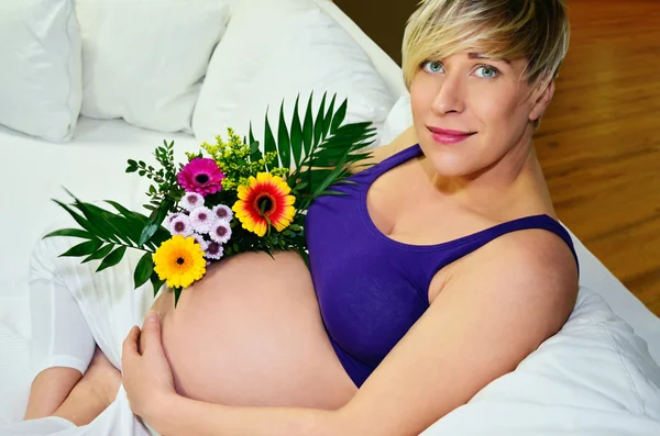 Vrouw zwanger met bloemen — Stockfoto