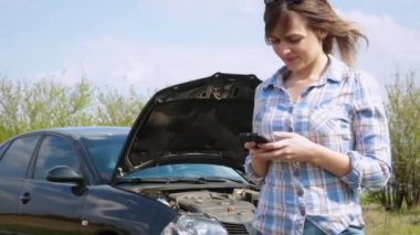 Akıllı telefon kullanan kız telefon numarası onarım servisine girdi. Araba arızası konsepti, yardım beklemesi.