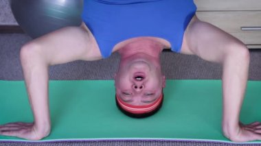 Komik adam amuda kalkıyor. Spor salonunda ya da evde elleri üzerinde duran bir adam. Spor, spor, sağlıklı ve yaşam tarzı konsepti