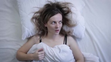 Baş ağrısından muzdarip genç bir kadının kameraya bakışının en üst görüntüsü. Üst görünüm