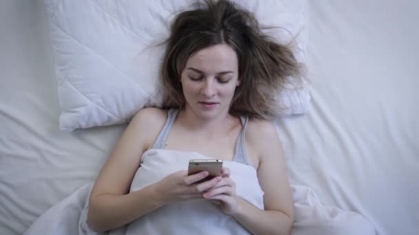 女人在床上用触摸屏智能手机的肖像 与朋友聊天 社交媒体 张贴照片 分享想法 顶视图 — 图库视频影像