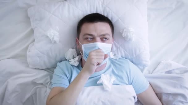 戴着医疗面罩的男人因为床上的流感咳嗽 头戴口罩的病人喉头酸痛 Coronavirus Covid 健康概念 — 图库视频影像