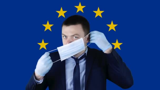 Människan Medicinsk Skyddsmask Mot Bakgrund Europeiska Unionens Flagga Coronavirus Covid — Stockvideo