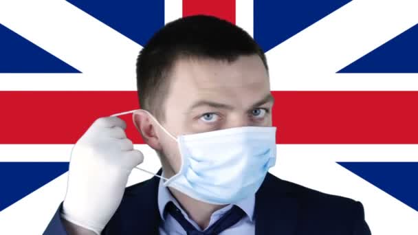 在英国国旗的背景下戴着医疗防护面具的人 Coronavirus Covid Sars Ncov 19健康 衰退和金融概念 — 图库视频影像