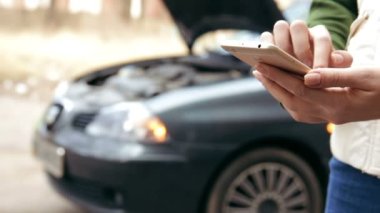 Kadın arabası bozulduğunda yardım istemek için telefonu kullanıyor..