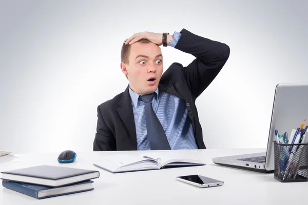 Shocked businessman with laptop computer and documents at office — Stock fotografie