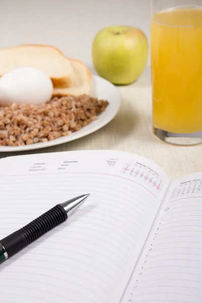 Defter buğday, ekmek, yumurta, elma ve bir bardak portakal ile 