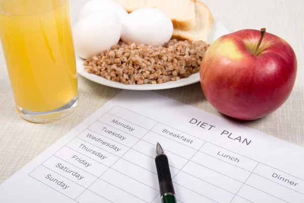 Diet plan with buckwheat,bread,eggs,apple and a glass of orange