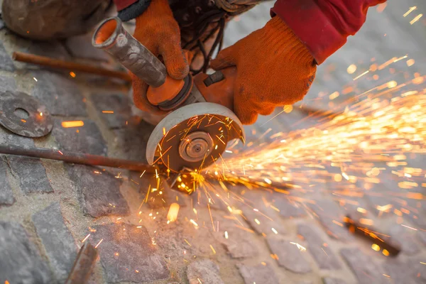 Angular grinding machine cuts metal with sparks