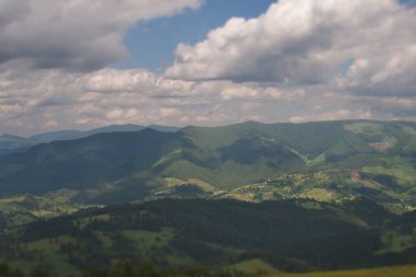 Karpat Dağları 'nın geniş yatay görüntüsü tepelerdeki bulutların gölgeleriyle.
