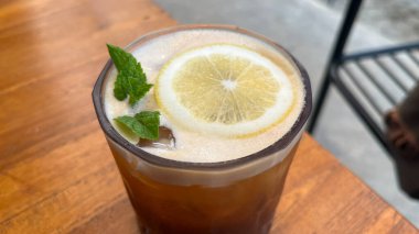 Buzlu kahve, nane şekeri ve dilimler masada. Espresso, portakal suyu ve şeffaf bardakta buzlu şerbet. Yaz modası ferahlatıcı kahve içeceği.