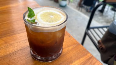 Buzlu kahve, nane şekeri ve dilimler masada. Espresso, portakal suyu ve şeffaf bardakta buzlu şerbet. Yaz modası ferahlatıcı kahve içeceği.