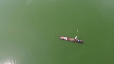 Balıkçıların bambu sallarda balık ağlarını göle atarken ve çekerken hava manzarası