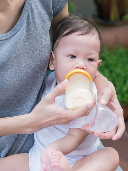 Aziatische moeder voeden fles haar baby. — Stockfoto