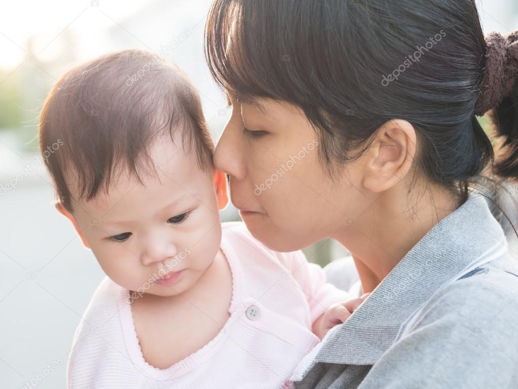 Asian mother kissing baby