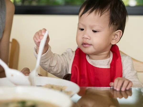 Asiático niño aprender a comer comida ella misma . —  Fotos de Stock