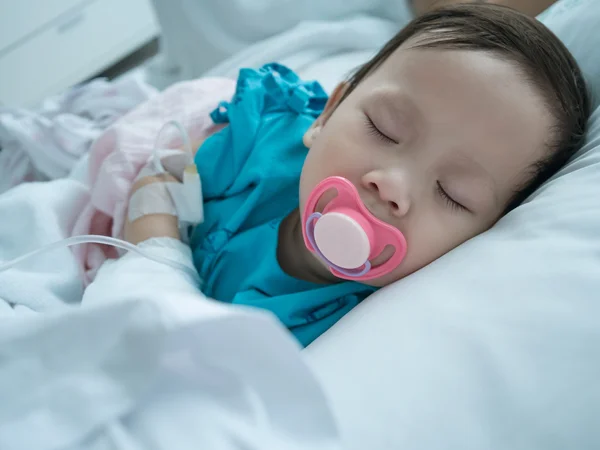 Bebé durmiendo en cama enferma en el hospital en la recepción intravenosa . —  Fotos de Stock