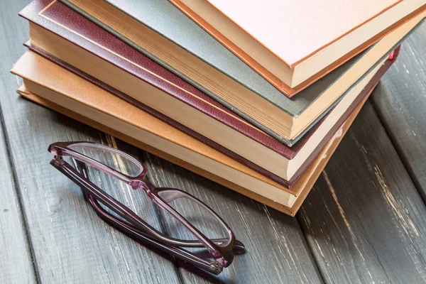 Una pila de libros viejos y vasos para leer — Foto de Stock