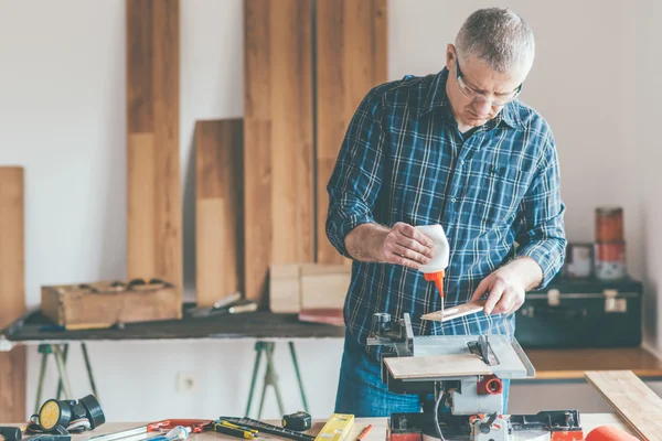 Carpenter applied glue on wooden board — Stock Photo, Image