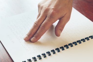 Görme engelli yaşlı kişi okunurken dokunarak öğrenme