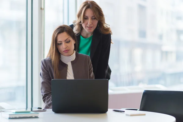 Zwei lächelnde Geschäftsfrauen arbeiten zusammen — Stockfoto