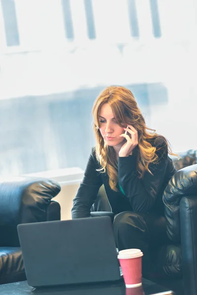 Femme d'affaires souriante faisant un appel téléphonique dans son bureau — Photo