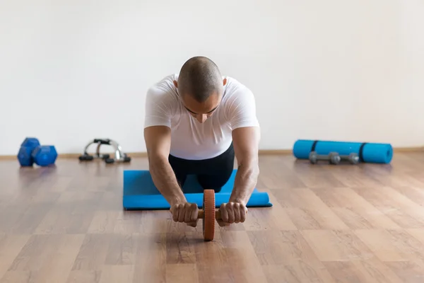 Sportler beim Training mit Bauchrollenrad. — Stockfoto