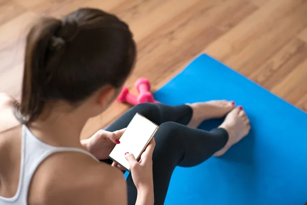 Fit woman using a mobile phone in the gym... — Stock Photo, Image