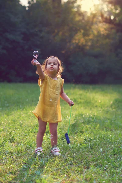 Little girl playing with soap balloons. — Stock Photo, Image